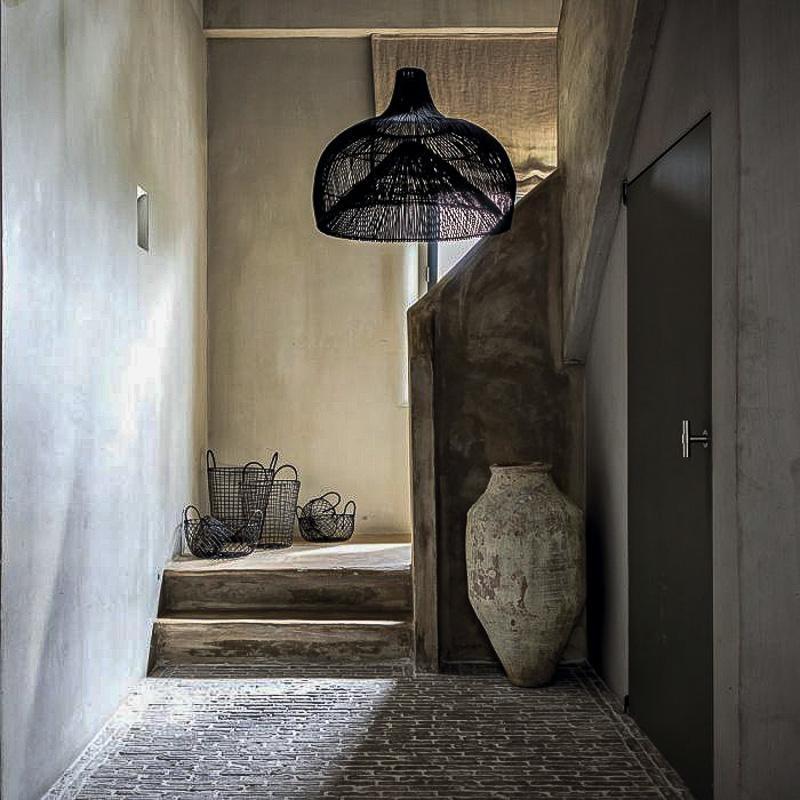 Stijlvolle zwarte rotan hanglamp Maggie in een modern interieur met landelijke elementen, Scandinavische en Bohemian accenten.