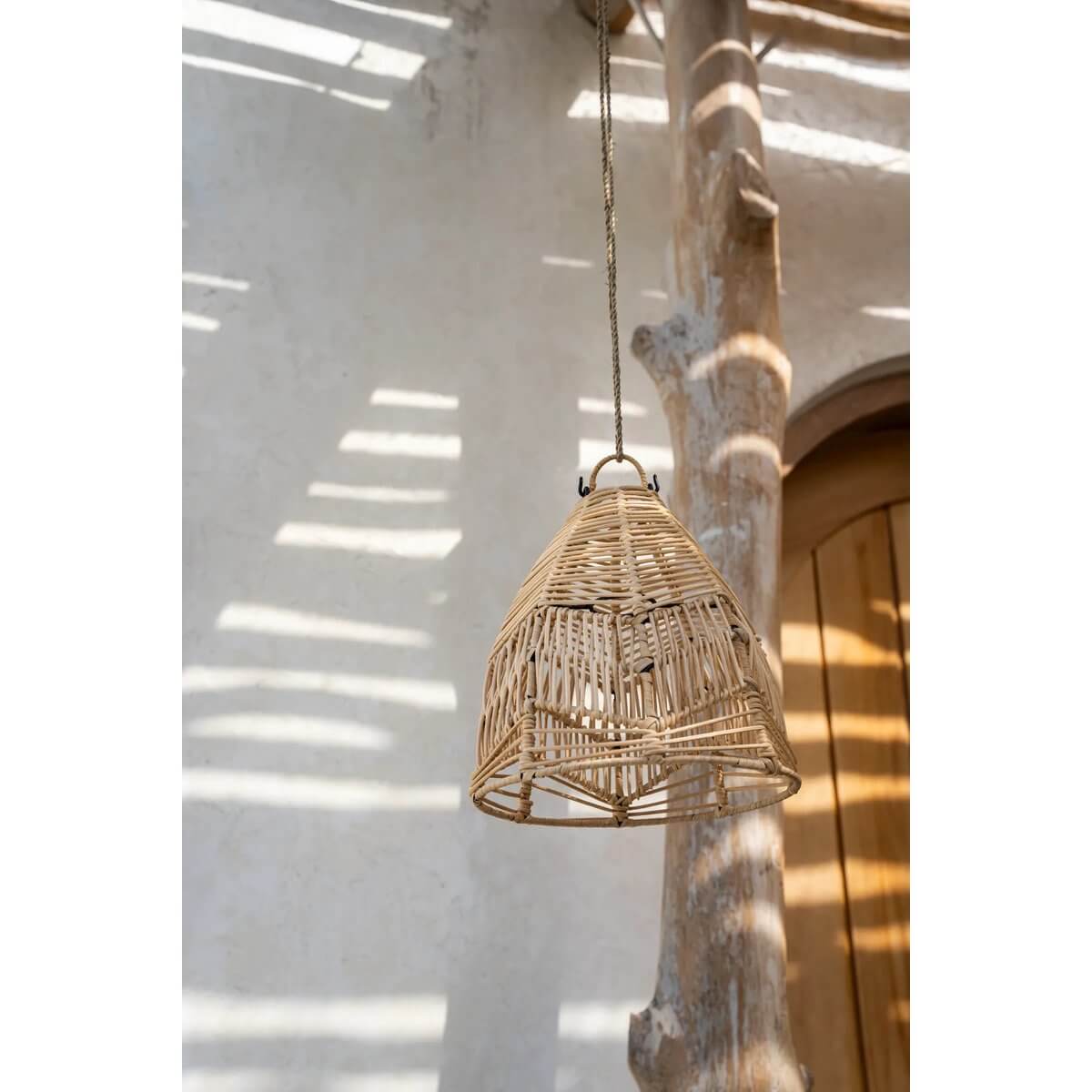 Bohemian style handwoven rattan pendant lamp hanging against a rustic background with natural light accents.