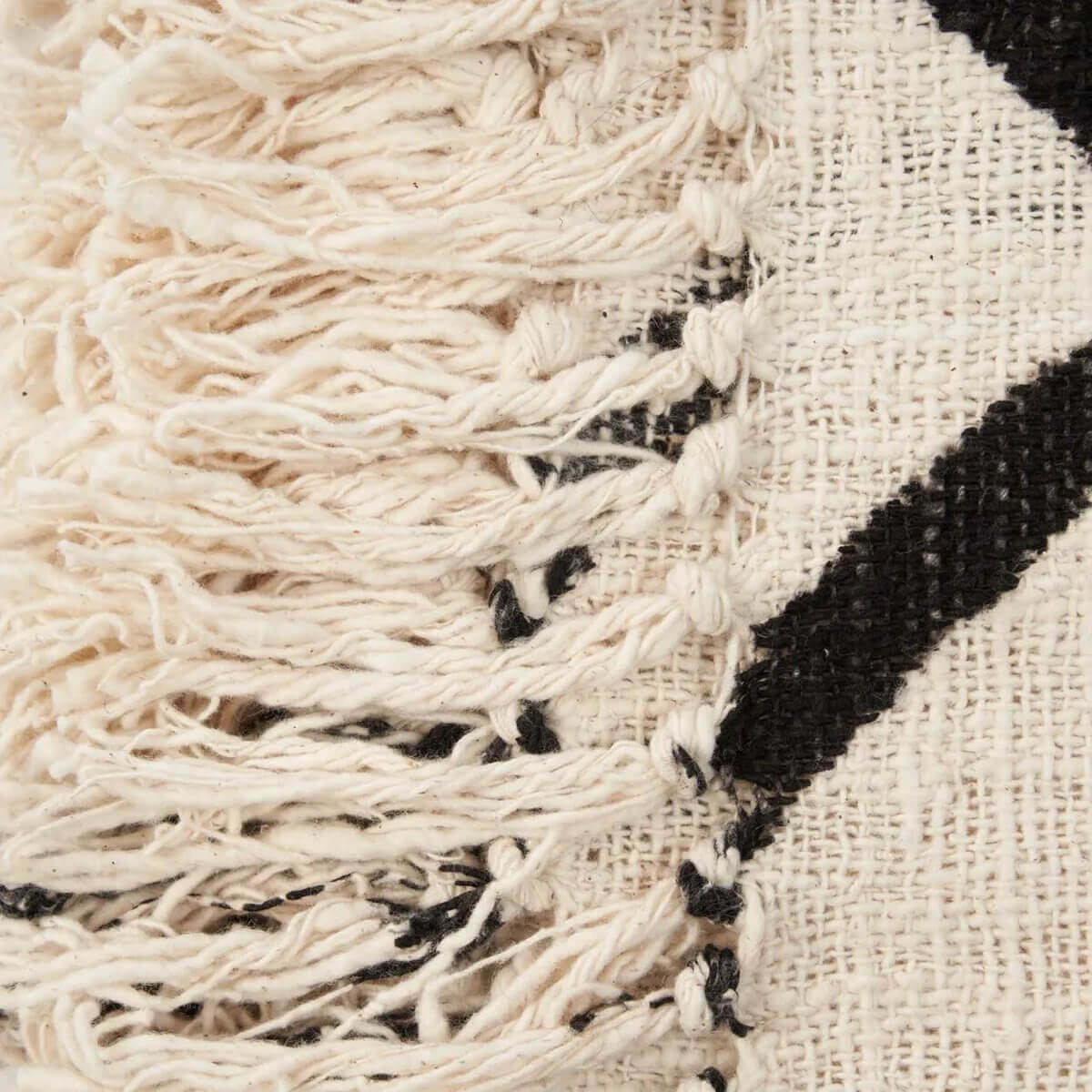 Close-up van de Evil Eye Bedsprei met zwart-wit patroon en natuurlijke textuur in katoen. Mystiek ontwerp voor stijlvolle interieurs.