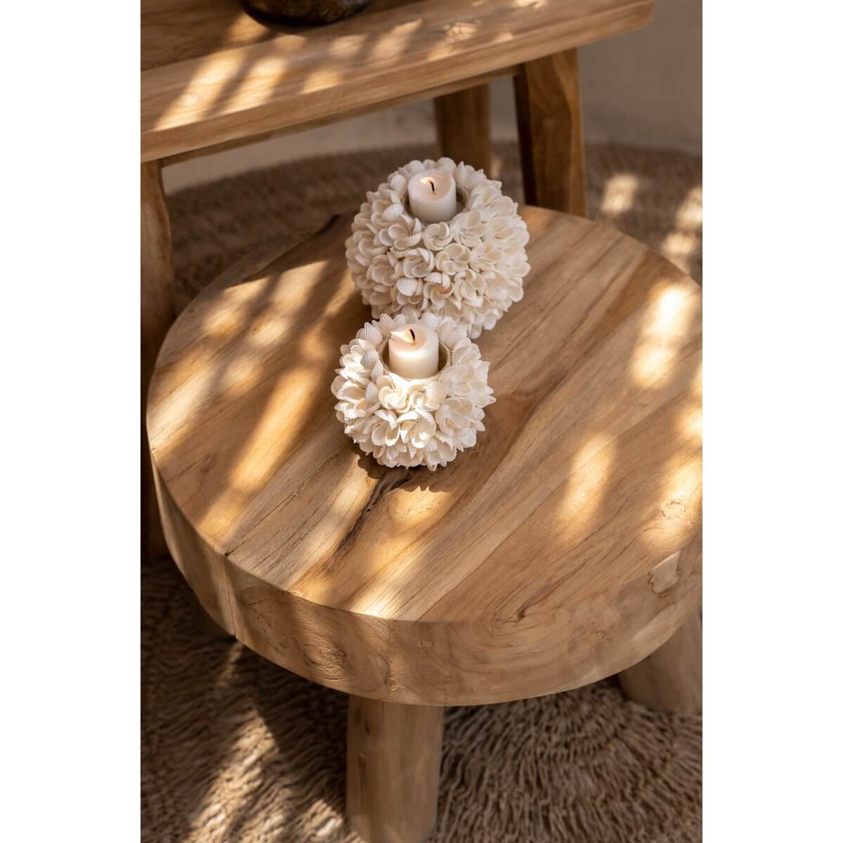 Handmade bohemian kandelaar with flower-shaped design from Bazar Bizar Living, casting a soft glow on a rustic wooden table.