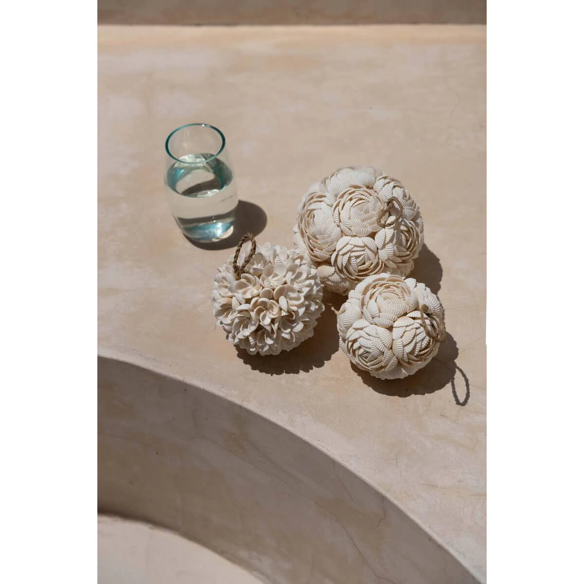 Handcrafted rose shell balls in white, displayed elegantly on a surface, perfect for bohemian decor and artistic home styling.