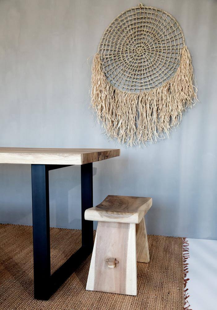 Stijlvolle houten meubelset met wanddecoratie en vlechtwerk voor een serene interieurstijl.
