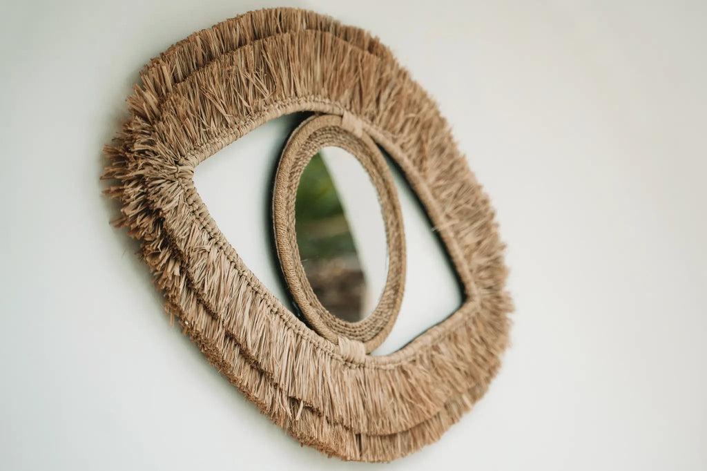 Boho style Raffia Eye spiegel aan de muur, perfect voor kust- en boho-interieurs, decoratief en functioneel in de hal of woonkamer.