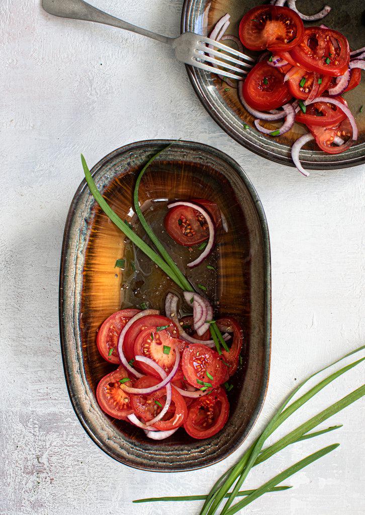 Tomatensalade in ovale Portugese keramieken kommen van de Comporta Collectie met craquelé glazuurafwerking.