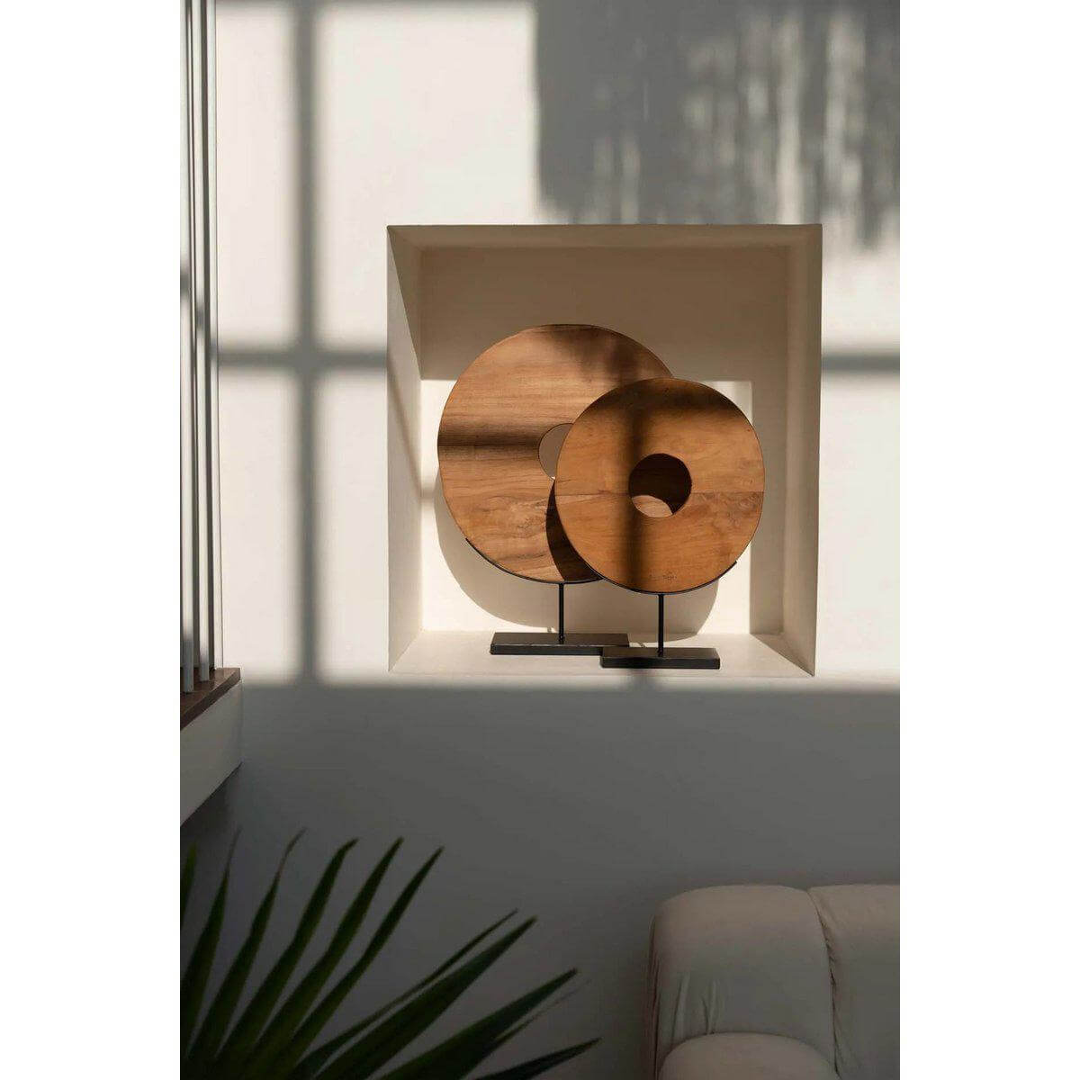 Teakhouten cirkeldisplay op standaard in een moderne ruimte, ideaal voor interieur- en tuindecoratie.