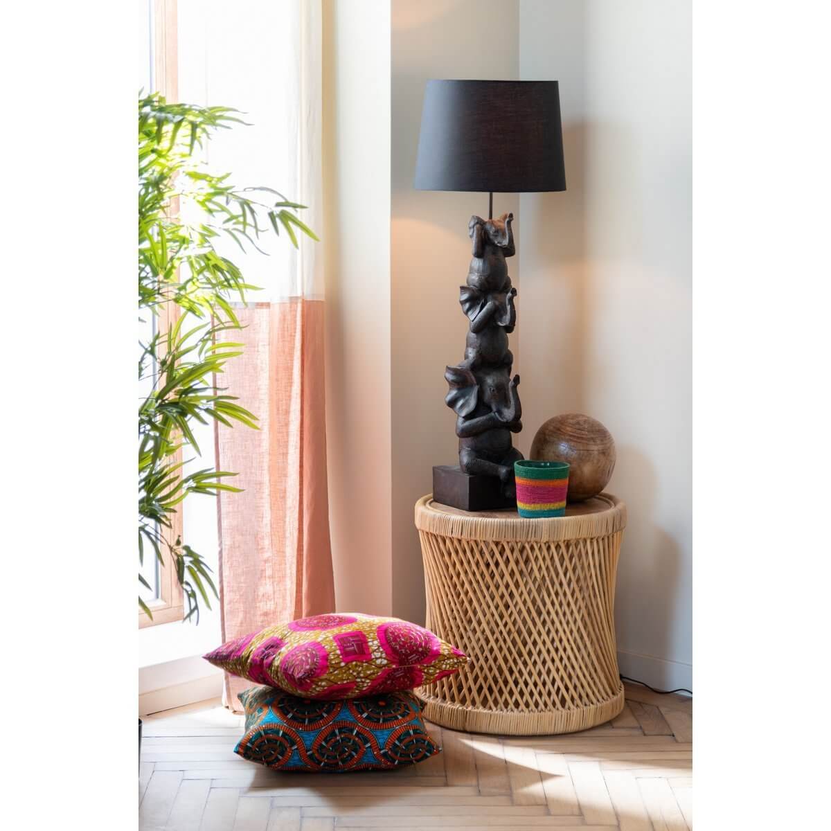 Rotan bijzettafel met lamp, decor, en kleurrijke kussens, natuurlijke uitstraling voor in de woonkamer.