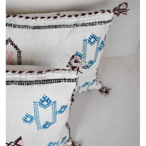 Marokkaans kussen gemaakt van vintage Berber tapijt met unieke blauwe en rode patronen, perfect voor woon- of slaapkamer.