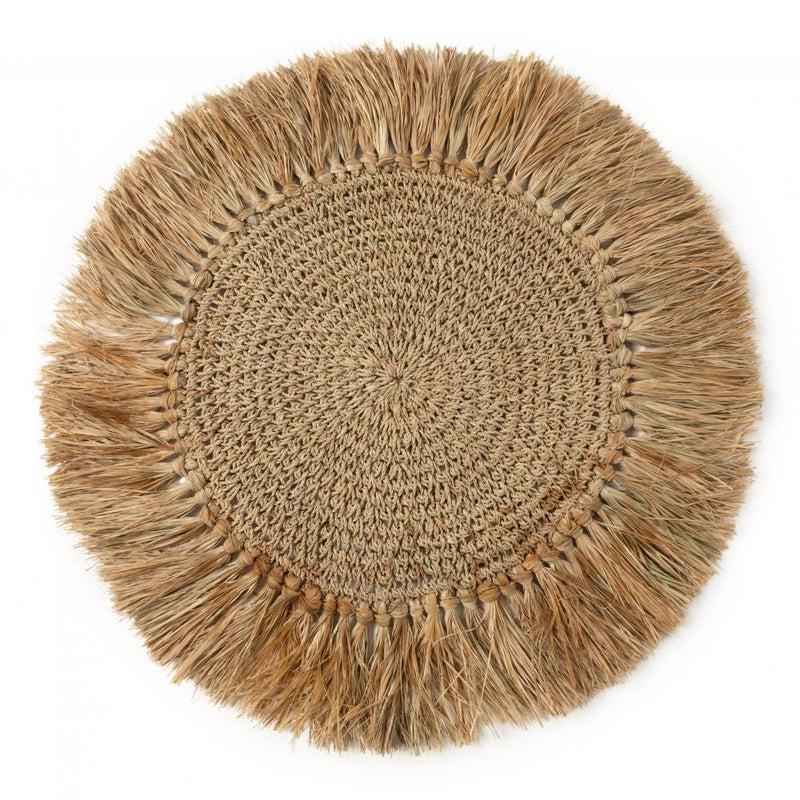 Handgeweven raffia placemat met rotan en kauri schelpen, ideaal voor een tropische tafelsetting.