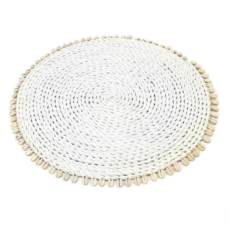 Ronde placemat van zeegras en raffia met kauri schelpen, ideaal voor een boho of kustinterieur.