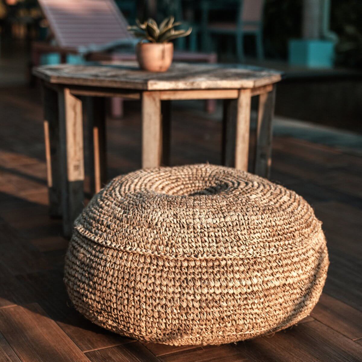 Ronde handgemaakte poef van raffia als decoratieve zitplaats in een woonkamer, beschikbaar in twee maten, plasticvrij verpakt.