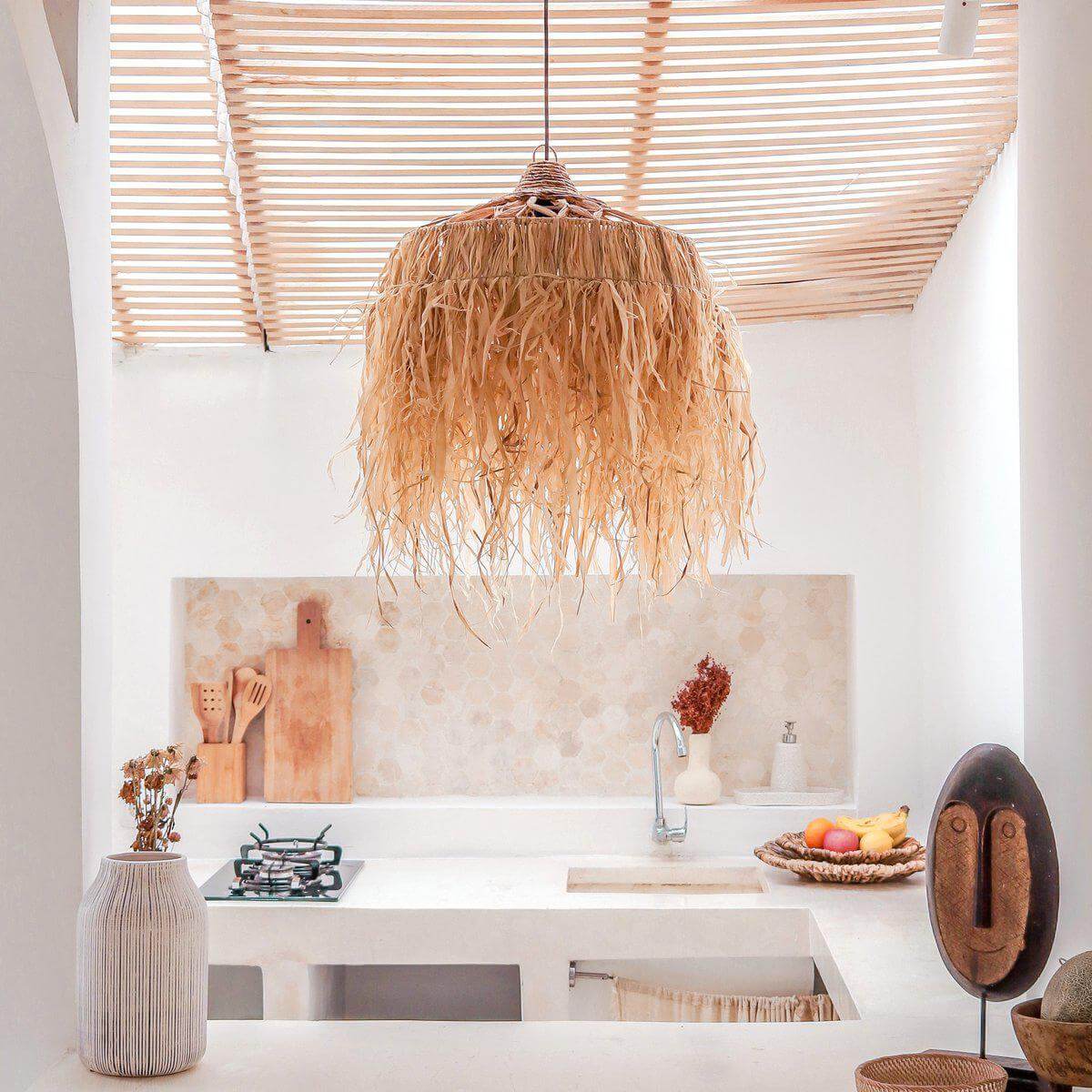 Hanglamp KAWI van raffia met lange franjes, handgemaakt en duurzaam, in een moderne keuken voor een warme en exotische sfeer.