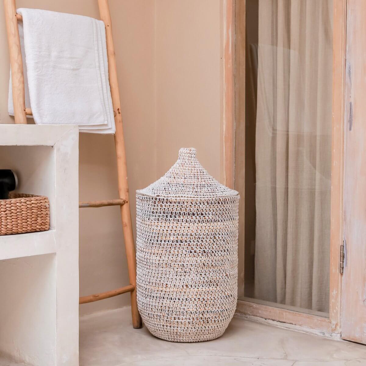 Wasmand met deksel van bananenvezels, 40 cm diameter, 57 cm hoog, naast ladder en wand in gezellige kamer.